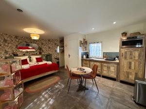 a bedroom with a bed and a table and a kitchen at Le Mas aux Amoureux , Suite Romantique et Spa in Le Barcarès