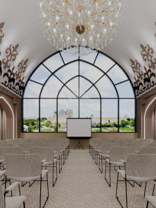 a large room with a large chandelier and a stage at Medina Palace in Türkistan