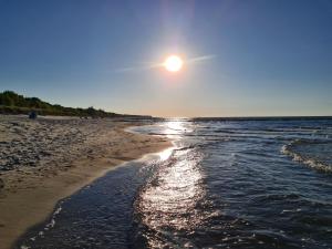 a beach with the sun rising over the water at Bungalow "Achtern" in Zingst