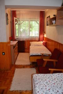 バラトンボグラールにあるRózsa nyaralóházのベッド2台と窓が備わる小さな客室です。