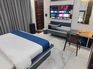 a bedroom with a bed and a desk and a tv at Hotel River View Panipat in Pānīpat