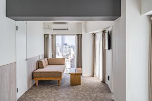 a living room with a chair and a window at Apartment Hotel 11 Asakusa 1 in Tokyo
