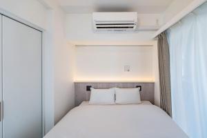 a small bedroom with a bed and a window at Apartment Hotel 11 Asakusa 1 in Tokyo +17 photos