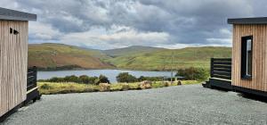 a road between two buildings with a view of a lake at Croft Seven Cabins in Port na Long