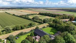 eine Luftaufnahme eines Bauernhofs mit Scheune und Feldern in der Unterkunft Apartment Deich - Moment in Krummendeich