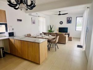 a kitchen and living room with a table and a couch at Villa AmNa in Grand Baie