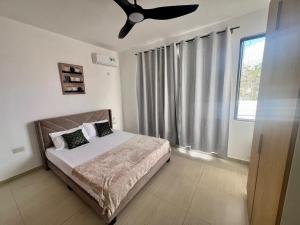 a bedroom with a bed with a ceiling fan at Villa AmNa in Grand Baie
