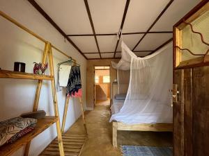 a room with a bed with a mosquito net at The Shamba in Kilifi
