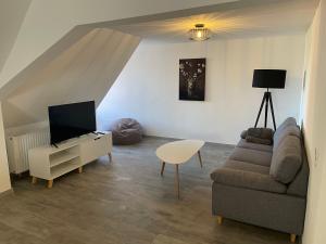 a living room with a couch and a tv at Black Forest apartment in Rottweil in Rottweil
