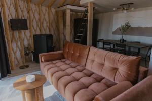 a living room with a brown couch and a table at Jurty Glamping in Gostynin