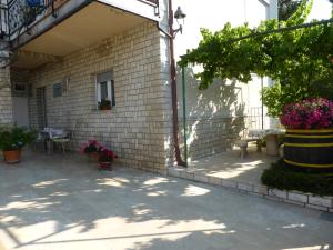 a brick building with a patio with a table and flowers at Rooms Vilena in Medulin