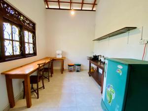 a kitchen with a wooden table and a blue refrigerator at Villa 4C in Midigama East