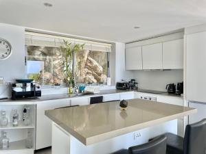 Una cocina con gabinetes blancos y una isla grande. en Residence 8 Suite 6, en Nathon Bay