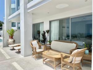 Un patio con sillas de mimbre y una mesa. en Residence 8 Suite 6, en Nathon Bay