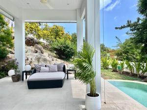 un patio con sofá y piscina en Residence 8 Suite 6, en Nathon Bay 12 fotos más