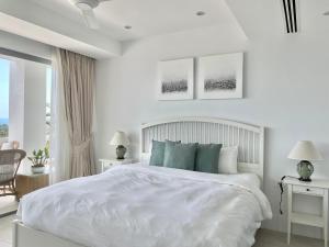 Un dormitorio blanco con una cama blanca y una ventana. en Residence 8 Suite 6, en Nathon Bay