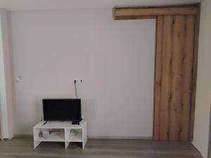 a tv sitting on a stand next to a white wall at Passage in Paraćin