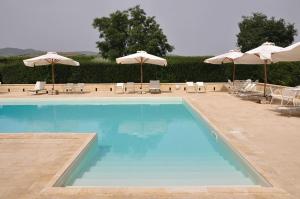 a large swimming pool with chairs and umbrellas at L'Orto di Lucania in Montescaglioso
