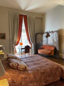 ein Schlafzimmer mit einem Bett und einem Stuhl und einem Fenster in der Unterkunft Château de Montigny-sur-Aube in Montigny-sur-Aube + 14 Fotos