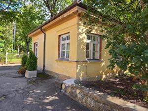 a small yellow building with a window on a street at Pasta Kvartāls Inn in Ogre