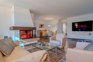 a living room with a couch and a fireplace at Entire House, Terrace, Garden, BBQ, 3 TVs - Zurich Region in Höri