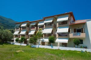 an apartment building with white awnings on it at Vessarios in Nikiana