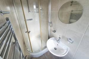 a bathroom with a sink and a shower and a mirror at Private Guesthouse in Manchester