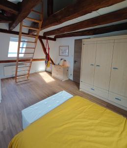 a bedroom with a large yellow bed in a attic at Les 5 Hiboux in Oberbronn