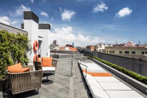 einen Balkon mit Bänken und Stadtblick in der Unterkunft Midtown Apartments in Barcelona