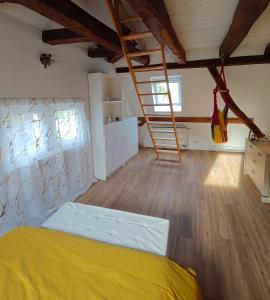 a bedroom with a bed and a wooden floor at Les 5 Hiboux in Oberbronn