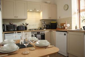 a kitchen with a table with plates and wine glasses at Abbies Place in New Mills