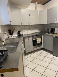 a kitchen with a sink and a stove top oven at Gästehaus Saarbrücken in Saarbrücken