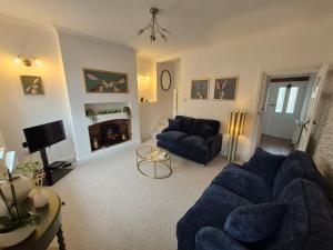 a living room with a blue couch and a fireplace at Abbies Place in New Mills