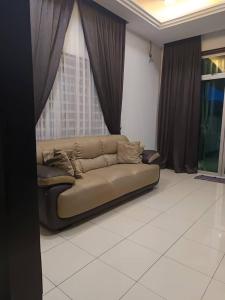 un divano in soggiorno con finestra di Homestay Kayangan Gua Musang a Gua Musang