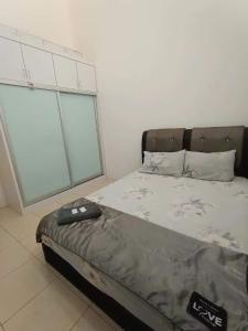 un letto in una camera con una grande finestra di Homestay Kayangan Gua Musang a Gua Musang