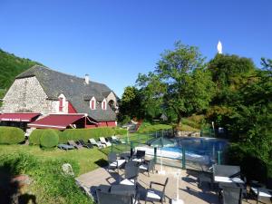 ein Haus mit einem Pool neben einem Gebäude in der Unterkunft Auberge de l'Aspre in Fontanges