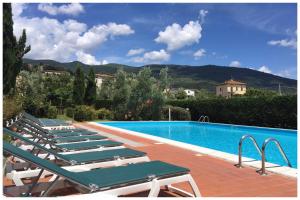 a row of lounge chairs next to a swimming pool at Agriturismo La Torricella in Pistoia