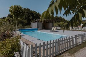 a swimming pool with a white fence around it at Jurty Glamping in Gostynin