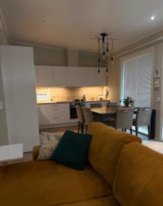 a living room with a couch and a kitchen at Rakkamaja Modern Forest-View Apartment in Rovaniemi
