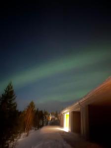a snow covered street at night with a building at Rakkamaja Modern Forest-View Apartment in Rovaniemi