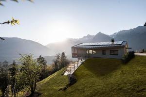 a house on a hill with mountains in the background at Florerhof in Schenna