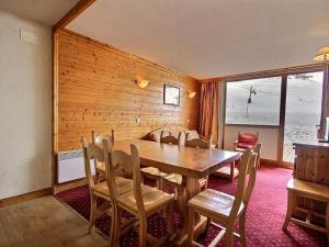 a dining room with a wooden table and chairs at Triplex 7 pers avec grande terrasse sur pistes - FR-1-455-73 in La Plagne