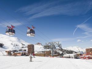a person riding a ski lift in the snow at Grand appartement spacieux pour 5 pers., balcon, accès direct aux pistes, Wifi - FR-1-455-167 in La Plagne