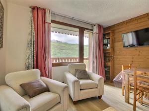 a living room with two chairs and a television at Charmant 2 pièces au pied des pistes avec balcon, pour 4 personnes - FR-1-455-139 in La Plagne