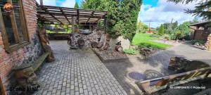a garden with a building with a bunch ofitures at Vilimu Sodyba - Stone Hall in Kriukai