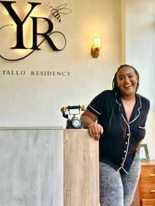 Eine Frau, die hinter einem Tresen in einem Raum steht. in der Unterkunft Yallo Residency in Nairobi