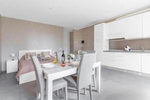 Una cocina y un comedor con una mesa y sillas blancas. en Eden Suite, Patio & BBQ near Lake Garda, en Castiglione delle Stiviere