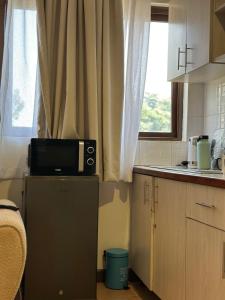 eine Küche mit einer Mikrowelle auf dem Kühlschrank in der Unterkunft Yallo Residency in Nairobi