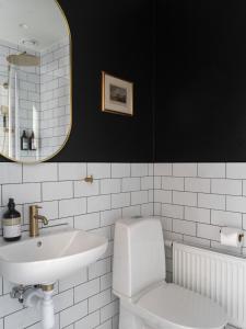 ルンドにあるホテル ビショップス アームズ ルンドの洗面台、トイレ、鏡のあるバスルーム +54枚の写真