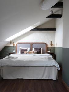 a bedroom with a large white bed in a attic at Hotel Bishops Arms Lund in Lund